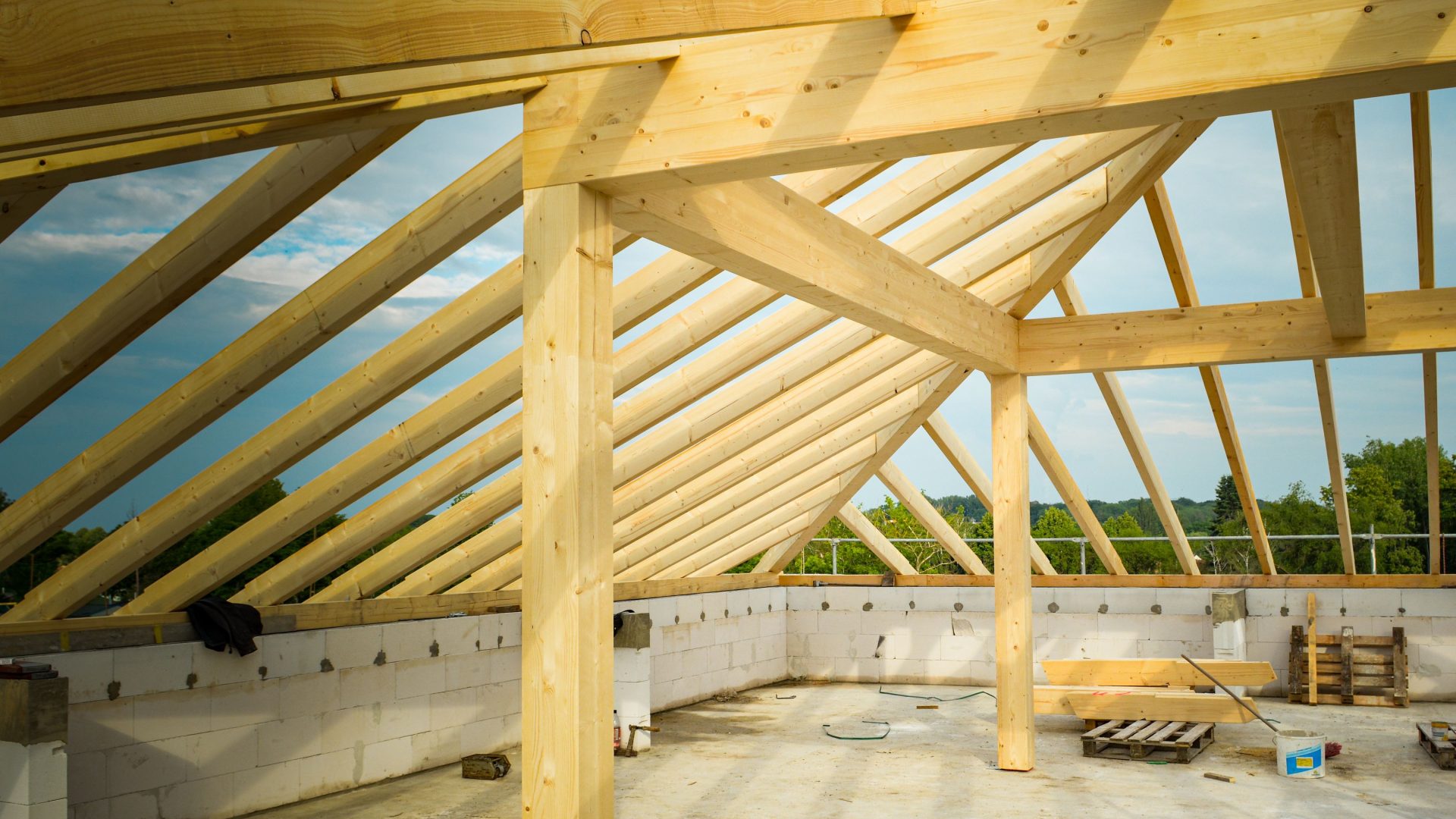 Zimmermann arbeitet an einer Dachstuhlkonstruktion aus Holz